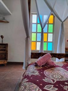 Un dormitorio con una cama con ventana y un niño. en Mi Atardecer en Tepoz, Hostal en Tepoztlán