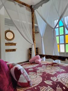 1 dormitorio con cama con dosel y almohadas en Mi Atardecer en Tepoz, Hostal en Tepoztlán