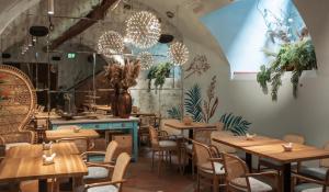 a restaurant with wooden tables and chairs at Apartamenty Sowa Toruń in Toruń