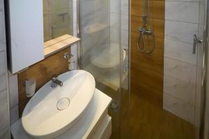 Un baño con lavabo blanco y ducha en City center, en Zajecar