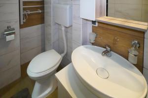 a bathroom with a white toilet and a sink at City center in Zaječar