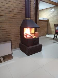 a fireplace in a living room with a tv at Chalés Bem-me-quer Itaipava in Itaipava