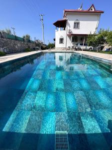 a large swimming pool with a house in the background at Villa Latanya in Dalaman