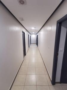 un pasillo de una oficina con paredes y puertas blancas en Dadar, en Larache
