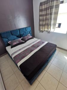 1 cama con cabecero azul en un dormitorio en Dadar, en Larache