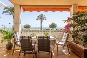 a table and chairs on a balcony with a view of the ocean at Apartamento Columbretes in San Juan de Alicante