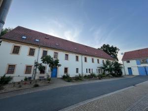 a white building with a red roof on a street at stilvolle Dachgeschoss-Wohnung in Top-Lage in Großröhrsdorf