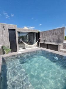 een groot waterbassin met een hangmat voor een huis bij Home Rooftop Private Jacuzzi 3 Bedroom 4 Bth 120Mb in Xcanatún