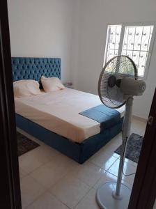 a bedroom with a bed with a fan next to a window at 2 bedrooms private townhouse in Zayed in Sheikh Zayed