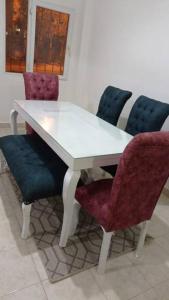 a white table with four chairs and a white table and chairs at 2 bedrooms private townhouse in Zayed in Sheikh Zayed