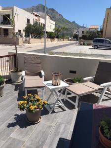 a patio with two chairs and a table and flowers at Casa Rosita in San Vito lo Capo