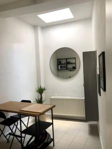 een kamer met een tafel en een spiegel aan de muur bij Private studio in Antwerp in Antwerpen