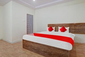 a bedroom with a large bed with red pillows at Flagship Hotel R Square Bn Reddy in Hyderabad