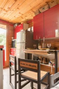 a kitchen with red cabinets and a stainless steel refrigerator at Le Mas de la Mélie in Arles