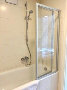 a shower with a glass door in a bathroom at Apartment Huberspitz - Ruhe, Berge & Natur in Hausham +11 photos