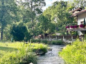 a river in front of a house and a building at Apartment Huberspitz - Ruhe, Berge & Natur in Hausham