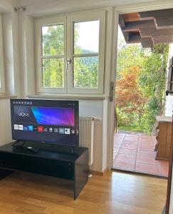 a living room with a flat screen tv in front of a door at Apartment Huberspitz - Ruhe, Berge & Natur in Hausham