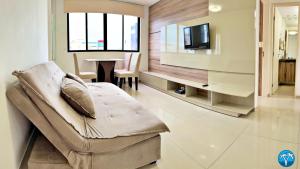 a living room with a couch and a television at Vacanze - Ametista 7 in Maceió