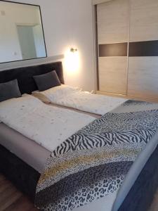 1 dormitorio con 2 camas y sábanas estampadas de cebra en Apartman ISPOD DUGE LANA en Zlatibor
