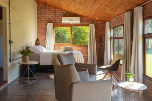 ein Schlafzimmer mit einem Bett und Stühlen sowie einem Fenster in der Unterkunft Cabana no Campo Caminho do Salto Ventoso in Farroupilha
