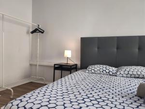 um quarto com uma cama e um candeeiro sobre uma mesa em DISCOVER PORTO - Boavista 2 em Porto