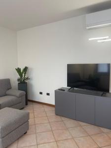 Una sala de estar con un televisor de pantalla plana grande. en Appartamenti HERA, en Lazise