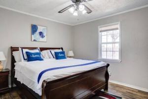 sypialnia z łóżkiem z niebieskimi poduszkami i wentylatorem sufitowym w obiekcie La Palma Lodge Near Texas Tech and Top Restaurants w mieście Lubbock