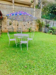 a table and chairs with an umbrella in a yard at Bunkhouse in Kandy