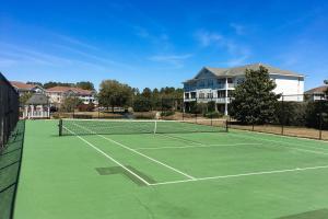 a tennis court with a net in front of a house at The Havens 1512 in North Myrtle Beach