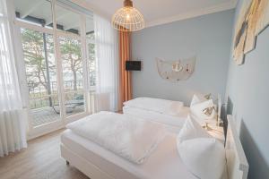 a white room with two beds and a window at Villa Baltik in Binz +25 photos