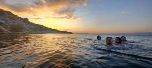斯库台Hyka Stone House Shkoder的日落时在水中游泳的人
