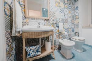 a bathroom with a sink and a toilet at Scinniamare in Cefalù +27 photos