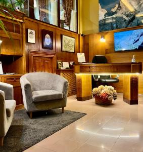 a living room with a piano and a chair and a desk at Hotel La Rivera in Arenas de Cabrales