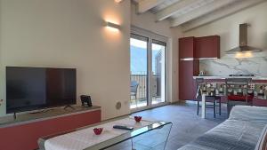 sala de estar con TV de pantalla plana y cocina en Calle - Larihome A37 en Dongo