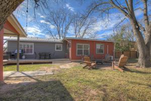 a house with two chairs and a table in the yard at Luxury Mid Century Charmer Near Historic Main St in Fredericksburg