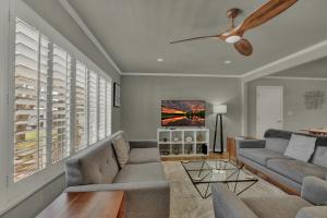 a living room with a couch and a ceiling fan at Luxury Mid Century Charmer Near Historic Main St in Fredericksburg