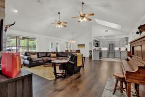 een woonkamer met een bank en een tafel bij Luxury Haus - GREAT Backyard, Firepit, Bocce Ball! in Fredericksburg