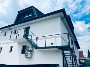 a white building with a staircase on the side of it at Villa Kovačeva apartments, Marice Kovačeve 15, app 1, free parking in Ljubljana