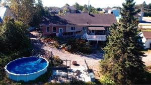 - une vue aérienne sur une maison avec une grande piscine dans l'établissement Au pied des Monts-Valin, hébergement touristique, à Saint-Honoré