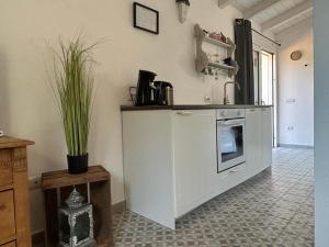 cocina con encimera blanca y microondas en LA PIANA Holiday House, en Bassacutena