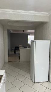 a kitchen with a white refrigerator and a table at Apartamentos na região Central Cobertura e 2 quartos in Ponta Grossa