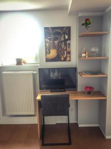 a desk with a television and a chair in a room at WINETIME in Oberhausen