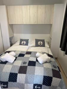 - une chambre avec un lit et une couverture en damier dans l'établissement Ahoi Haus Duo, à Drage