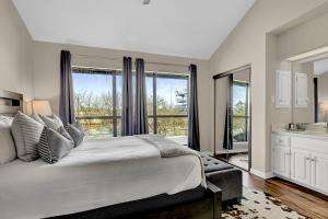 ein Schlafzimmer mit einem großen Bett und einem großen Fenster in der Unterkunft Luxury Riverfront Condo 1 BLK to Schlitterbahn! in New Braunfels