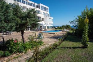 a resort with a swimming pool in front of a building at Aparthotel Romance in Kiten