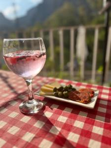 um copo de vinho e um prato de comida numa mesa em El nido del Chorro em Málaga