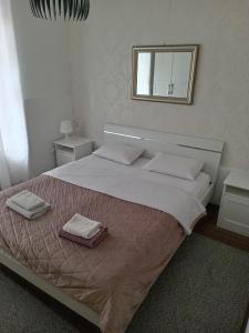 1 dormitorio con 1 cama grande y 2 toallas. en City Apartments Ana, en Belgrado