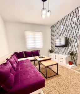 a living room with a purple couch and a table at Apartment Adel in Mostar