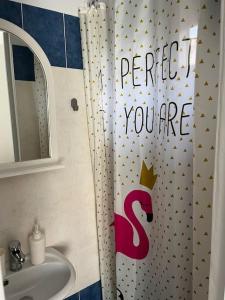 a bathroom with a shower curtain with a crown on it at Seas the Day in Preveza
