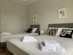 two beds with towels on top of them in a room at Seas the Day in Preveza